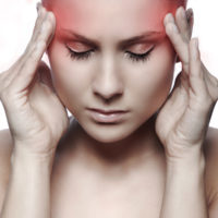 woman with headache on white background